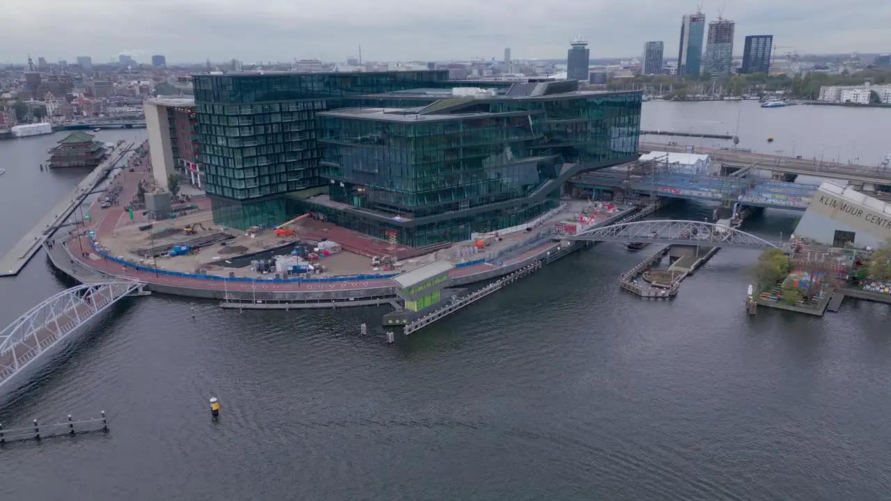 Modern corporate Building next to the amsterdam canal aerial drone shot