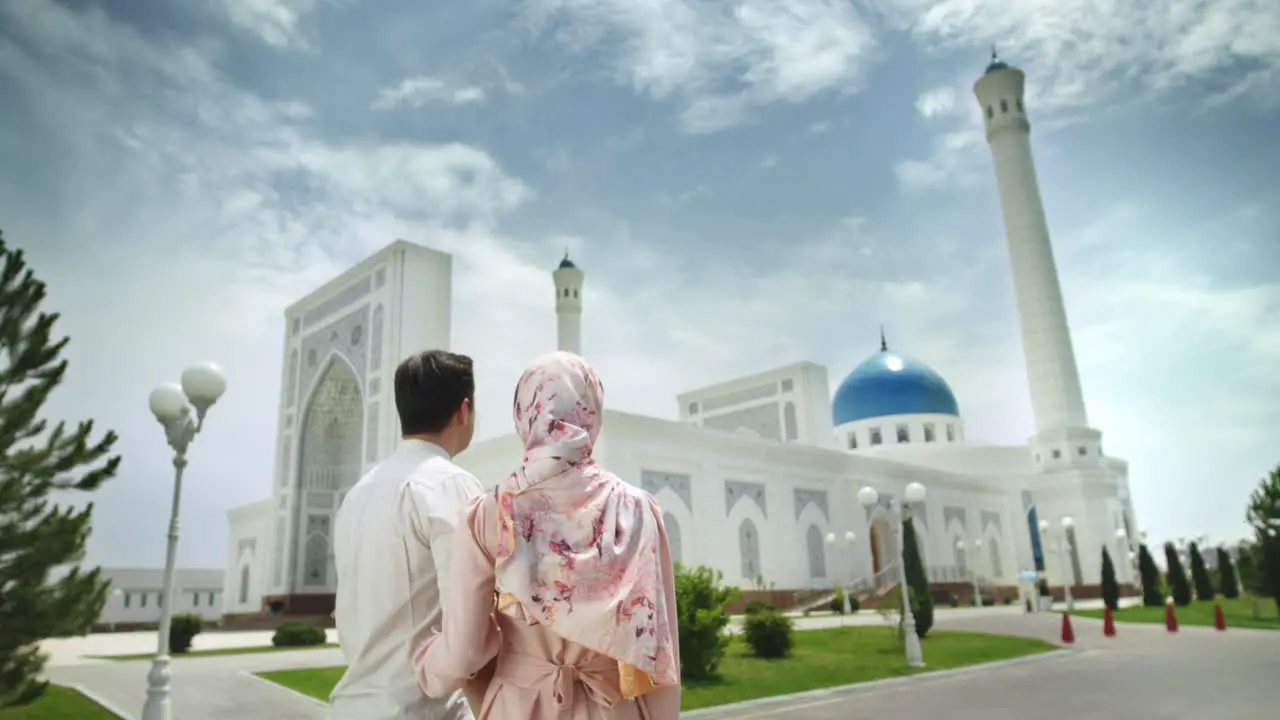 Husband and wife are staying in front of mosque