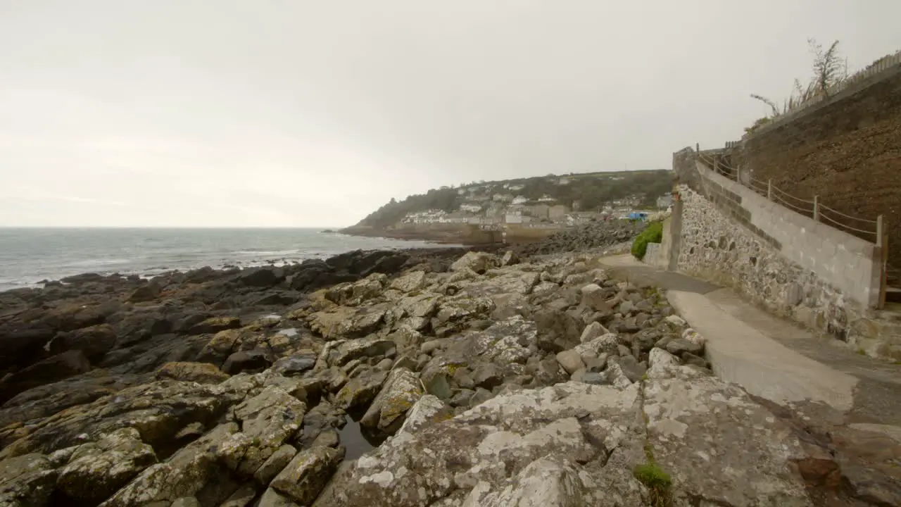 Shot showing rocky foreshore village of mousehole in background Cornwall