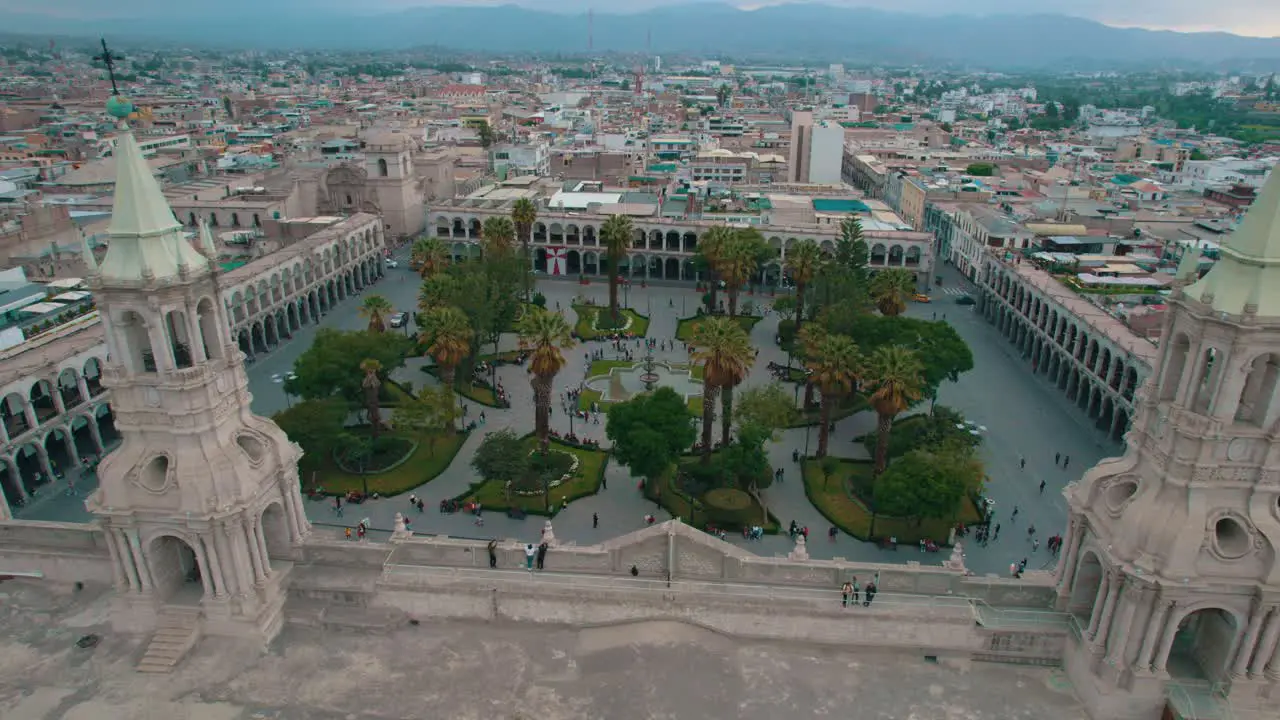 Cloudy day drone pan from left to right capturing the rear view of the Arequipa Cathedral its twin towers and the Plaza de Armas ending with a frontal view