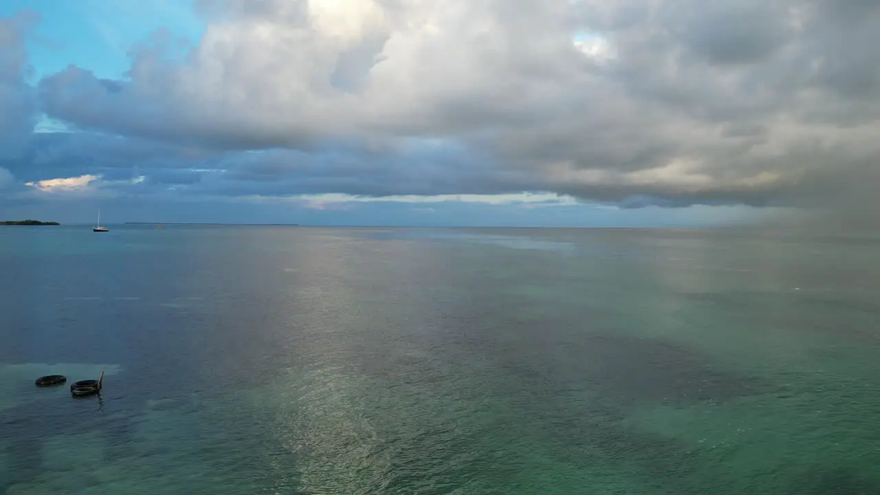 Drone view in Belize flying over caribbean dark and light blue sea shallow water coral reef and and a flying bird