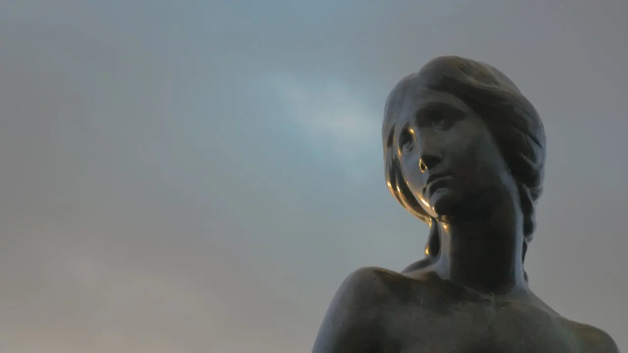 Face of Little Mermaid statue against sky background