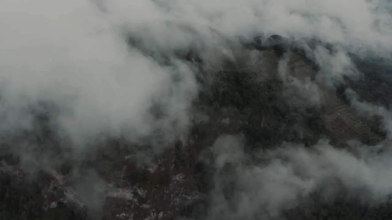 Drone aerial flying over the clouds towards a mountian and rainforest in Guatemala