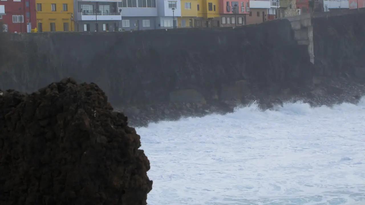 A big waves of the Atlantic Ocean breaks on a rocky coast on a sunny day during a storm in Puerto de la Cruz in the Canaries  medium shot