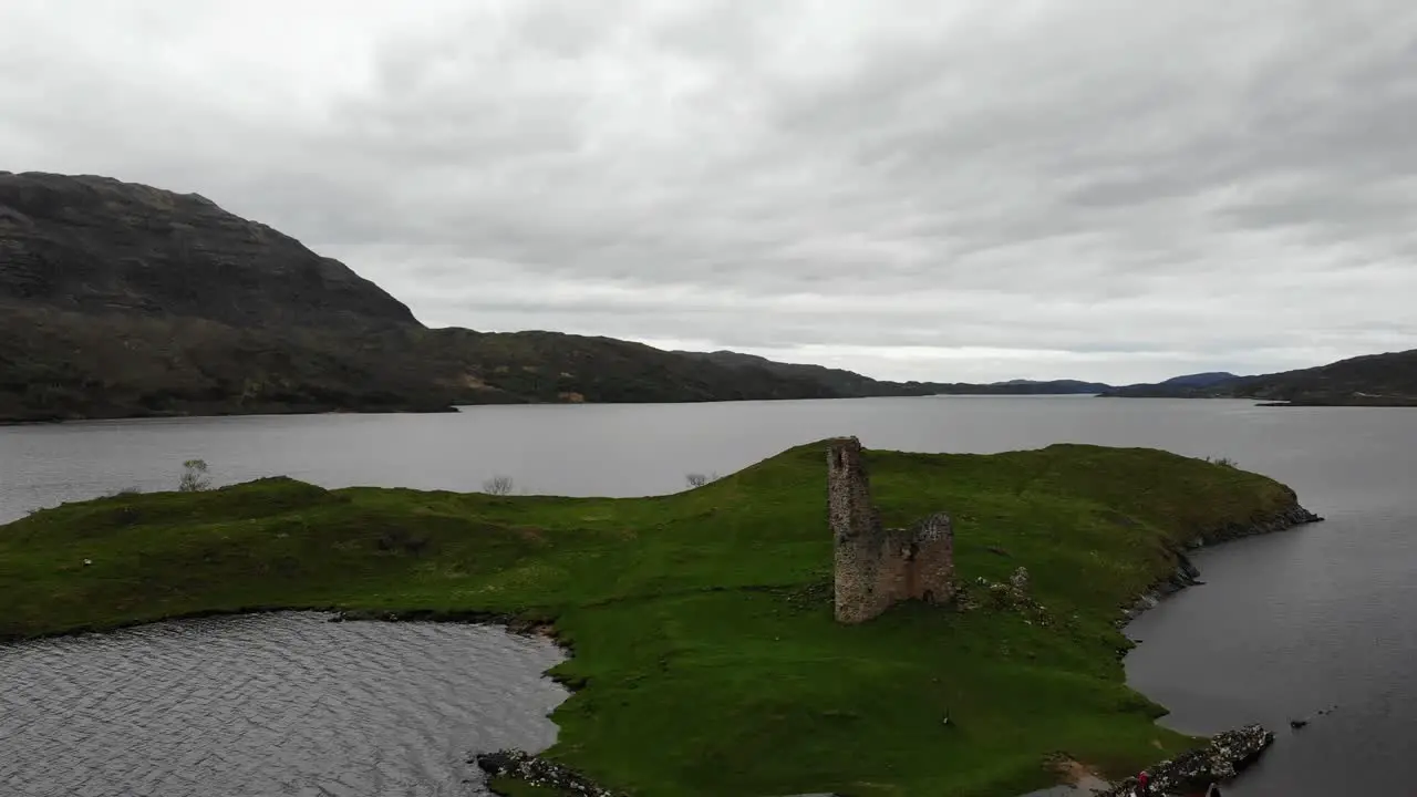 Aerial upwards shot of Ardvreck Castle Scotland with a moody sky backdrop