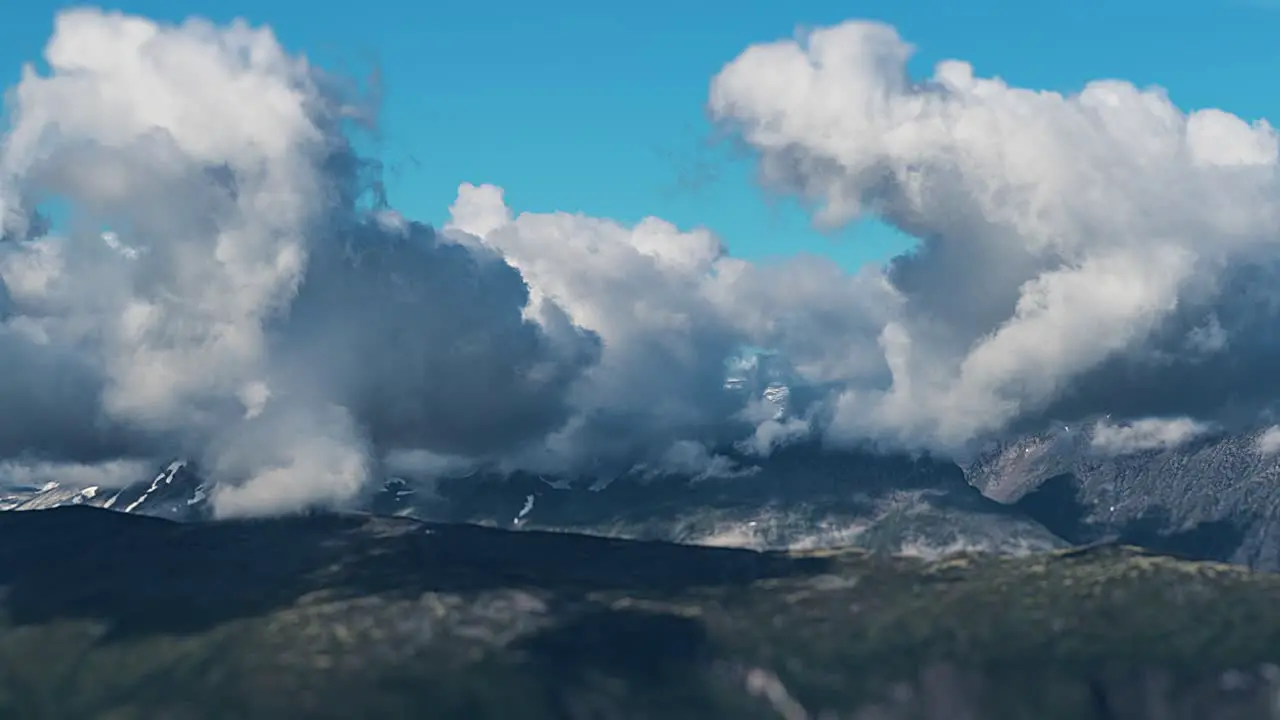 Dense clouds whirl above the vast mountainous plateau casting dark shadows on the ground