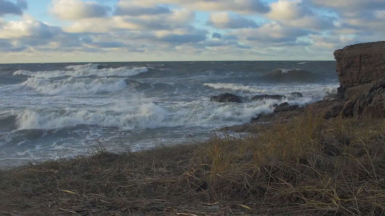 Big stormy waves breaking against abandoned seaside fortification building ruins at Karosta Northern Forts in Liepaja slow motion wide shot