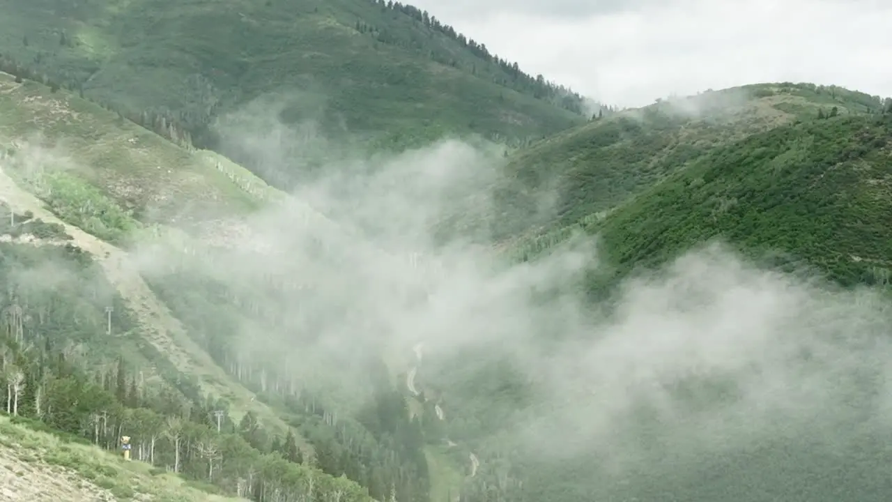 Aerial of low fog hanging over mountain and forest trees-1