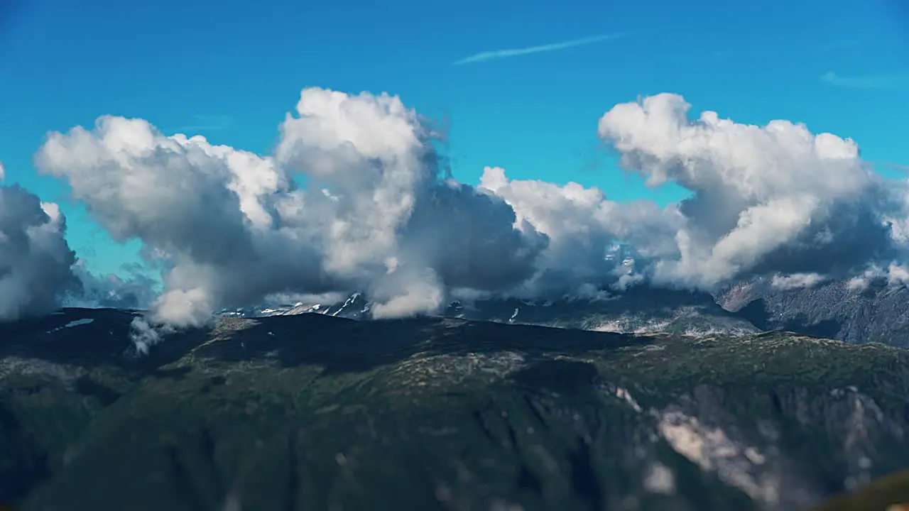 Greyish-white clouds whirl and hoover above the green plateau