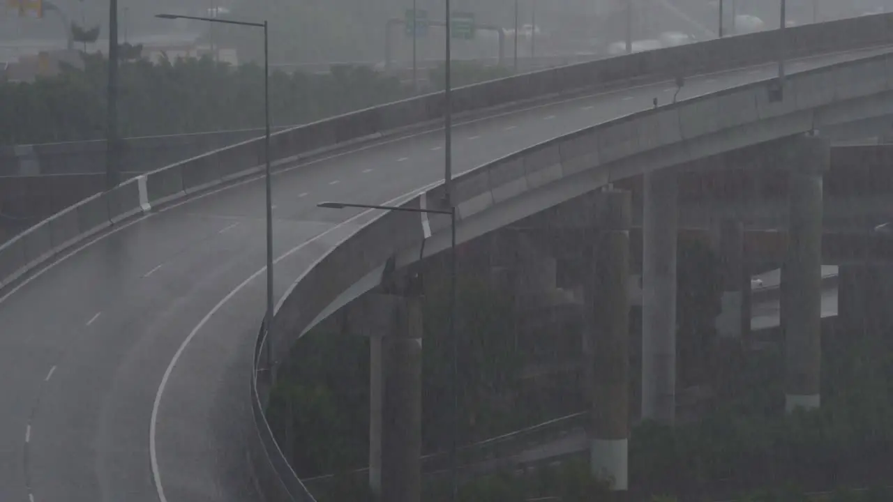 Queensland BOM weather forecast includes heavy rainfall severe storms and heatwave warnings in upcoming summer season static shot capturing quiet inner city bypass on a foggy and rainy day