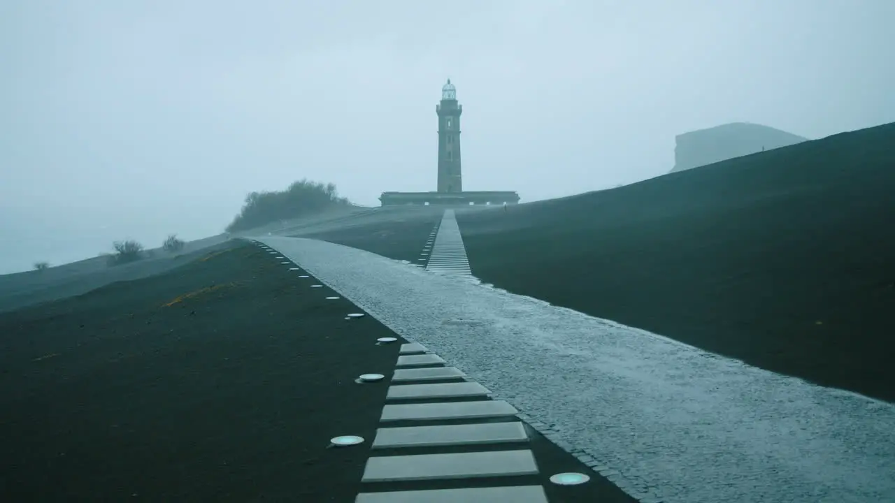 Stunning extreme wide shot of Ponta dos Capelinhos lighthouse on Faial island during a storm