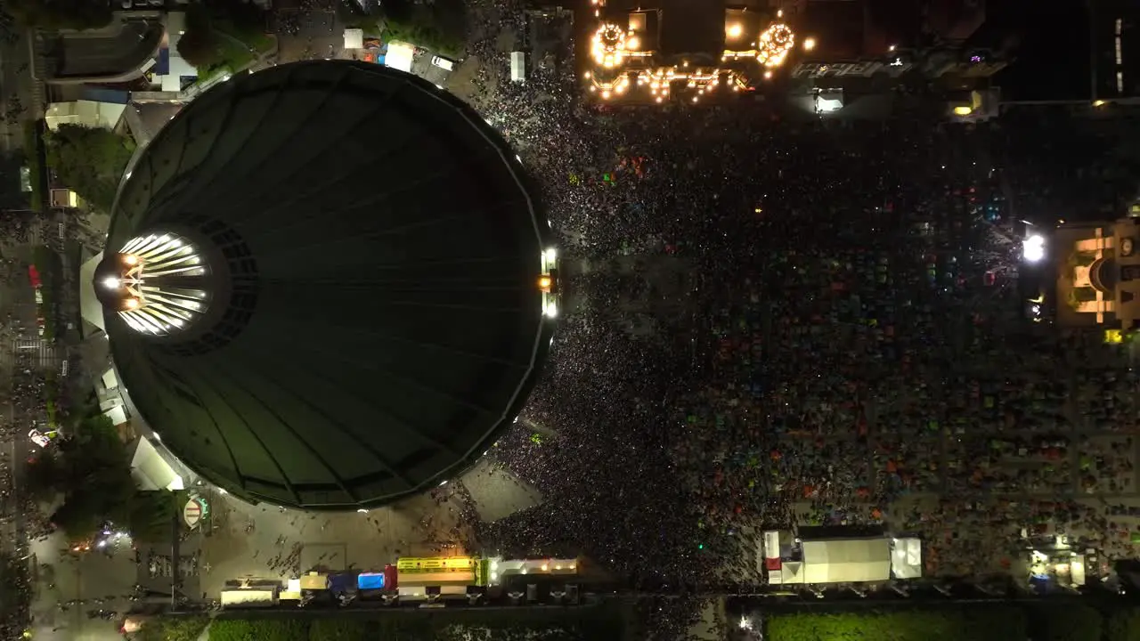 Aerial view above the Basílica de Guadalupe on Pilgrimage Virgin Day night in Mexico cenital drone shot