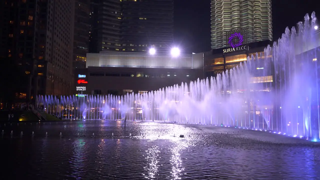 Fast tilt and pan down establishing shot over famous Petronas Twin Towers in Kuala Lumpur Malaysia