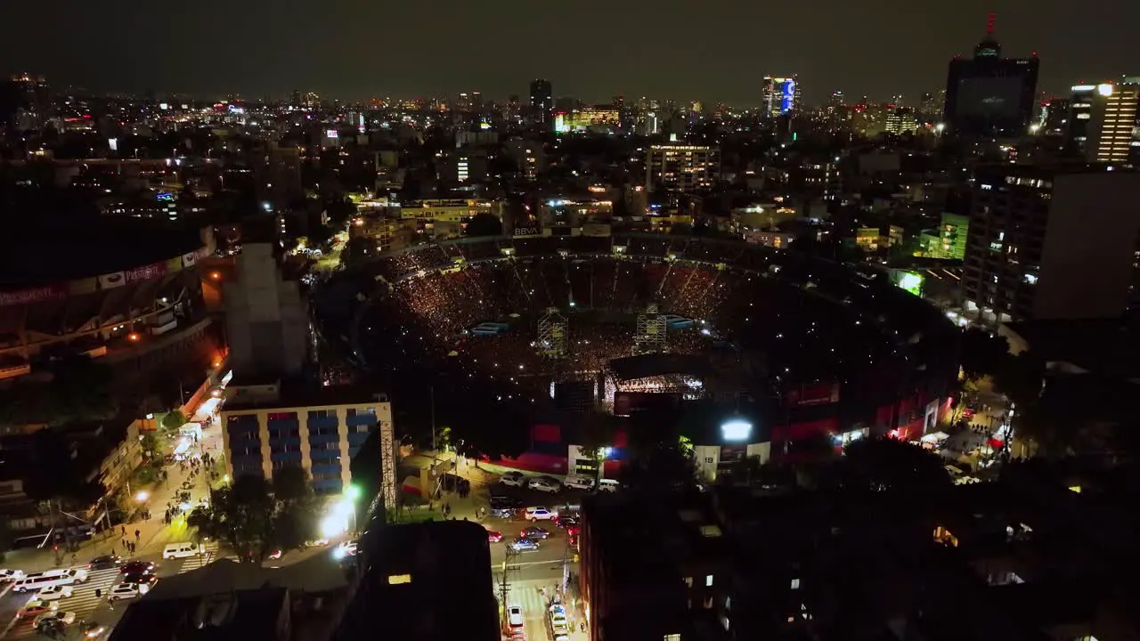 Aerial view of the Ciudad de los deportes Stadium during Concert night in Mexico city ascending tilt drone shot