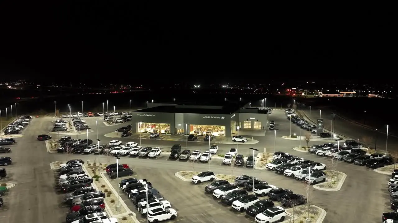 Jaguar and Land Rover luxury car dealership nighttime push in aerial