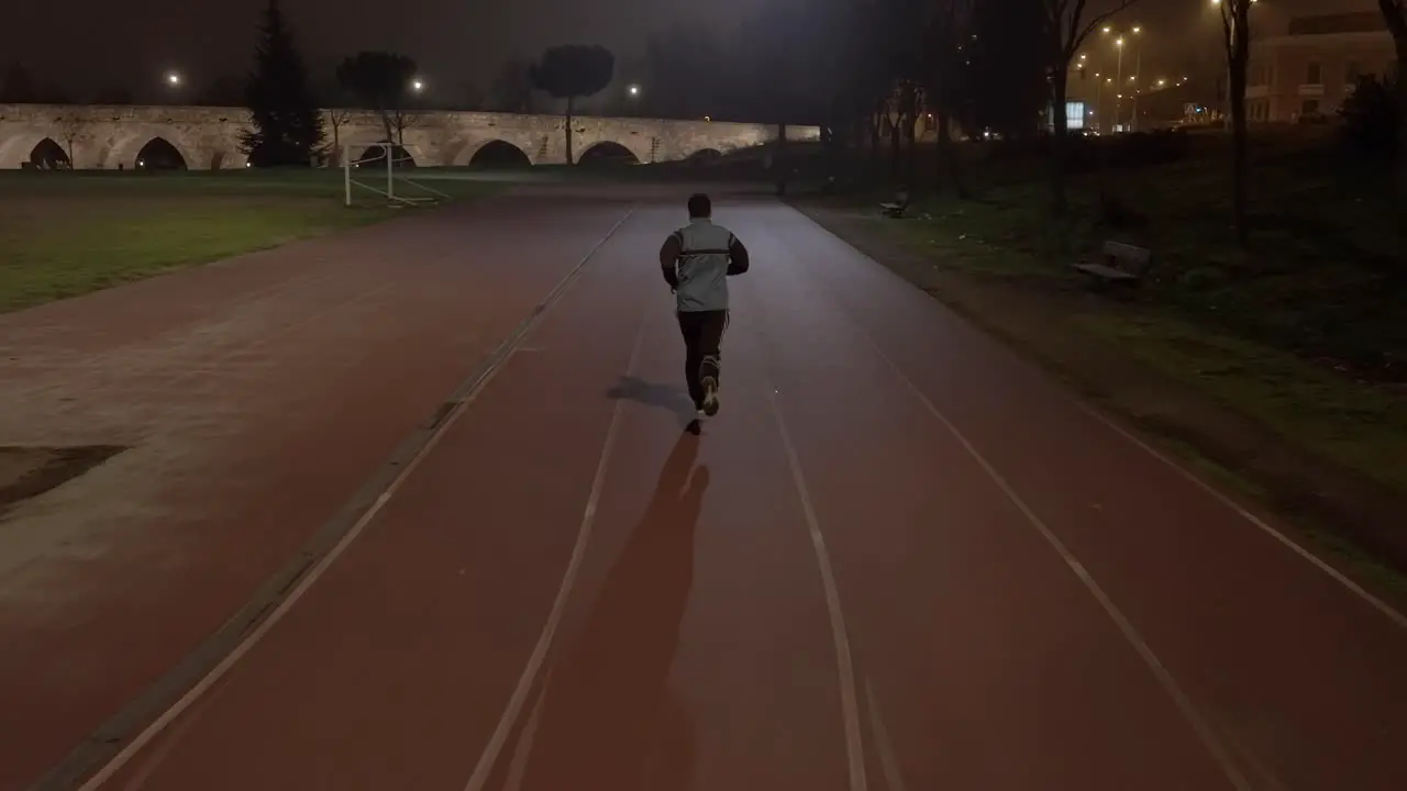 Tracking Shot Of Sportive Man Jogging On Track Towards Historical Aqueducts Spain