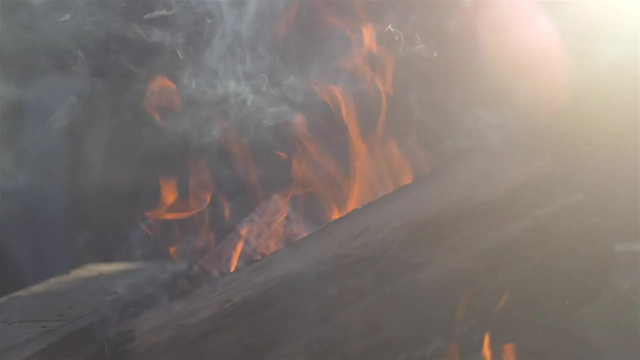 fire pit slow motion close up with sun flare on side