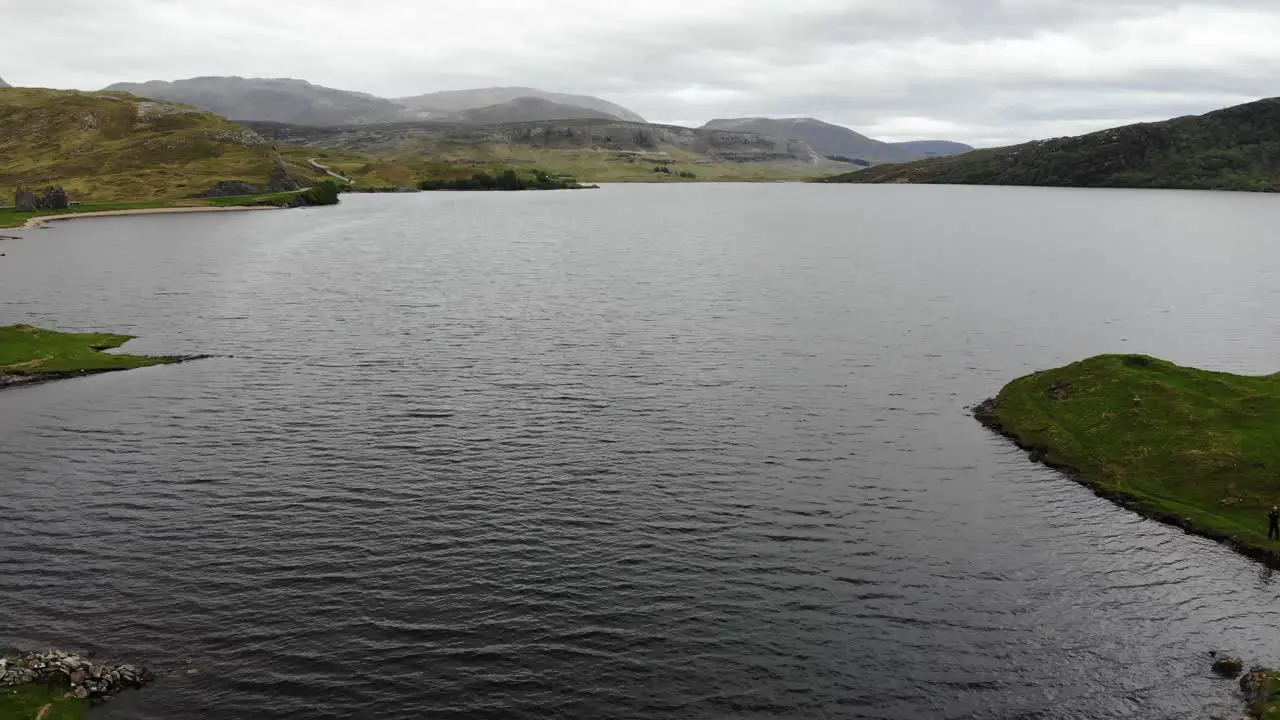 Aerial forward shot flying past the ruins of Ardvreck Castle in the Scottish Highlands