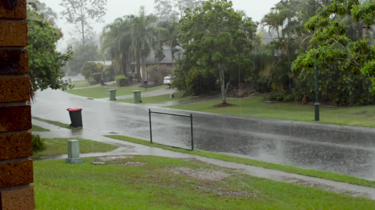 Car drives past as heavy rain falls in Brisbane on a stormy day