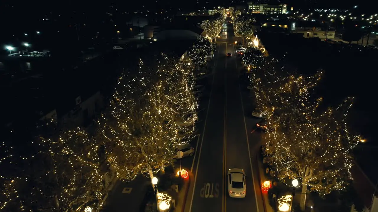 Christmas lights in a small town ascending aerial view reveals the street lights