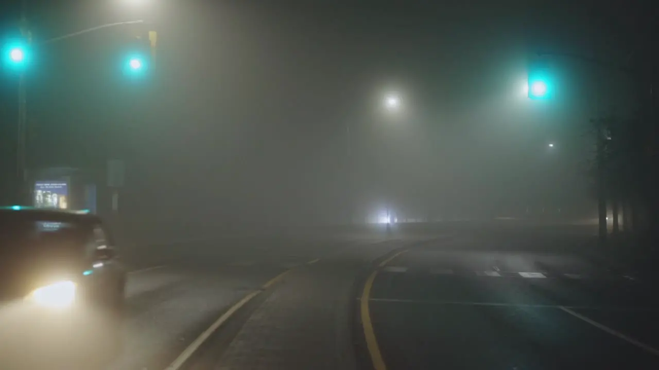 Vehicles Traveling On A Misty Highway During Nighttime wide static