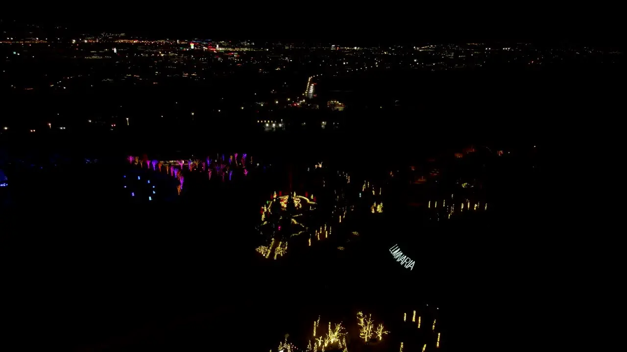 Christmas light festival in a garden park aerial push in tilt down