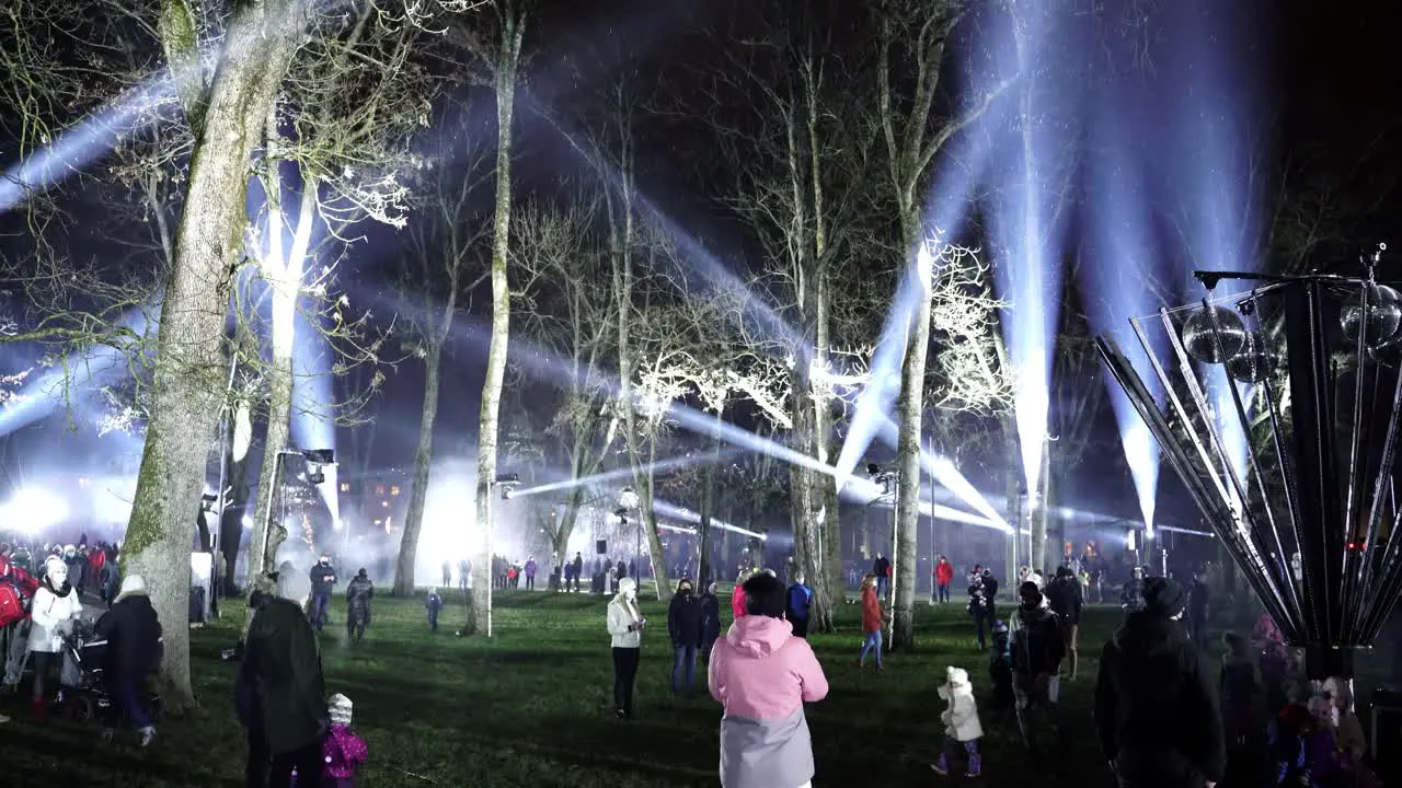 People admiring laser show at night