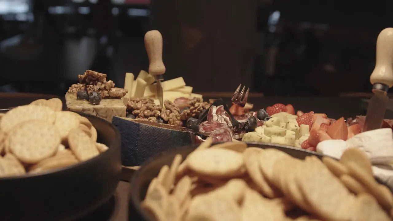 Close up of cheese and charcuterie platter on buffet at party bowls with crackers