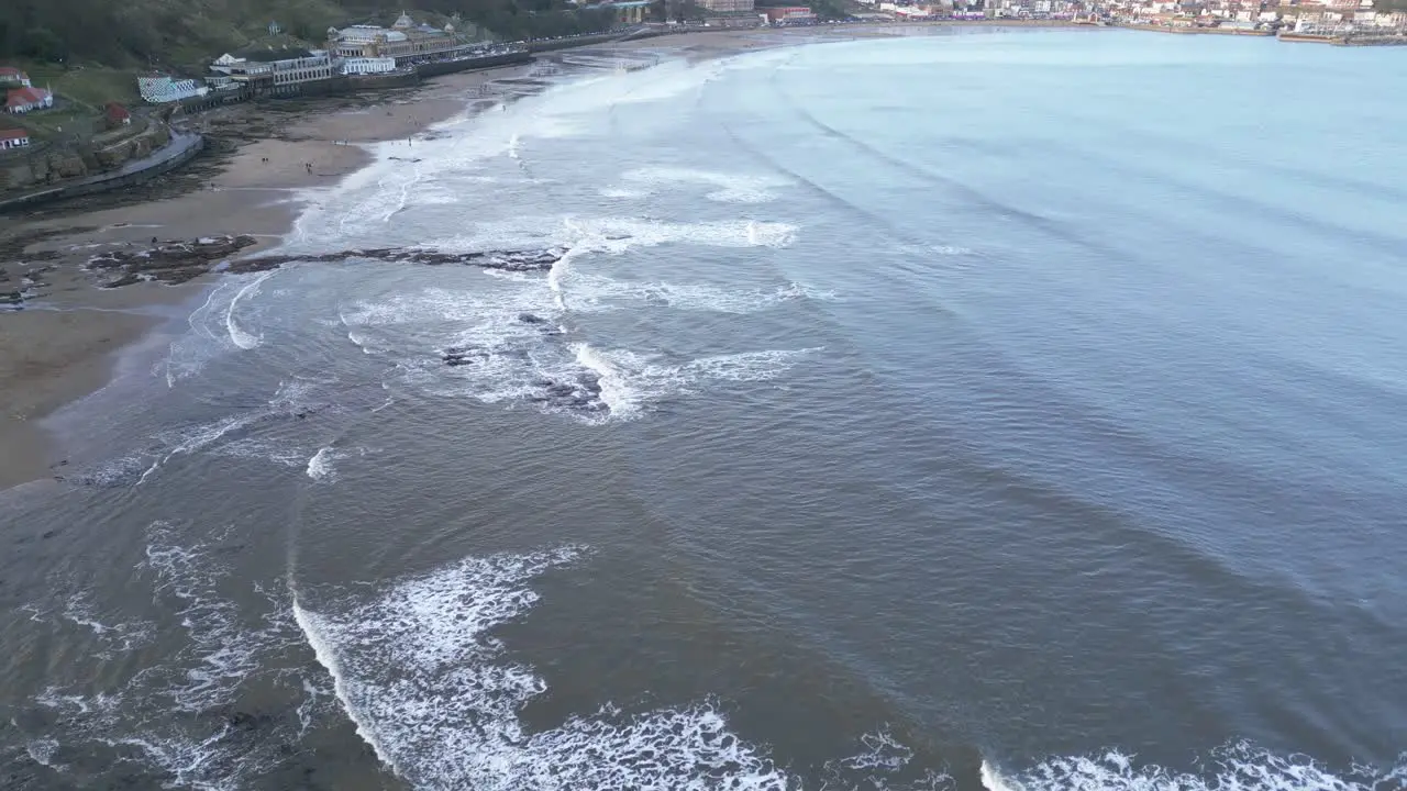 Aerial drone top down shot over beach along seaside in Scarborough North Yorkshire UK during evening time