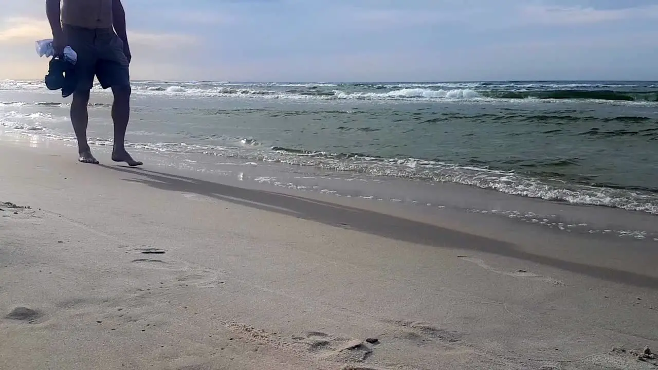 Man Walking Barefoot On Sandy Beach