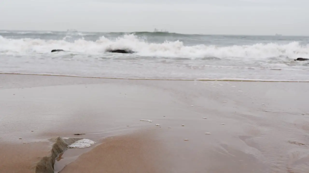 tracking shot of waves crashing on rocky beach