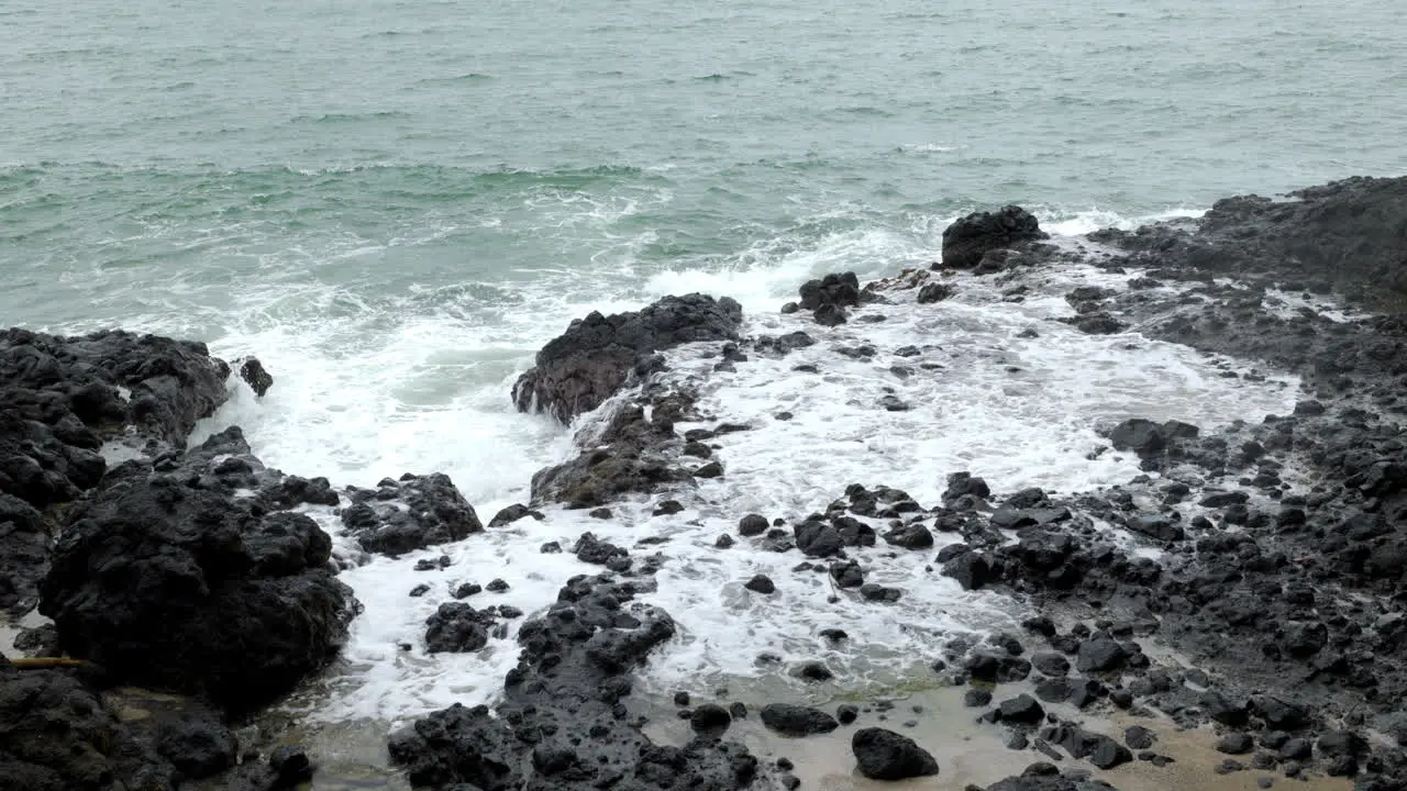 Waves crashing with great force against the rocks raising the water a lot