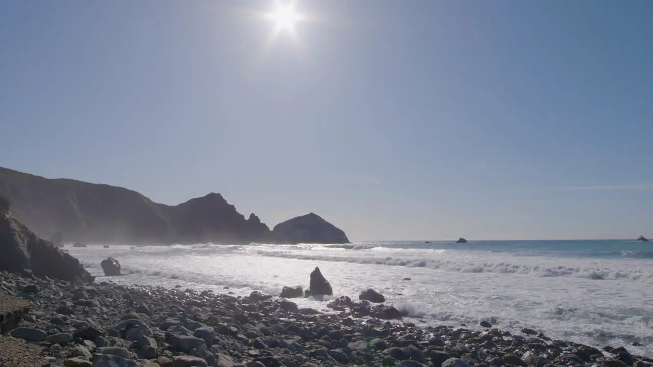 Time lapse ground level shot of the shore of Big Sur beach with calming waves rolling in located in California