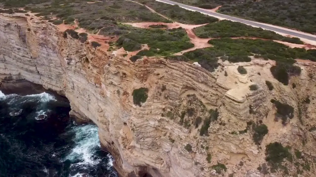 Flying over the beautiful turquoise foamy waves of the magnificent ocean and the impressive limestone cliffs