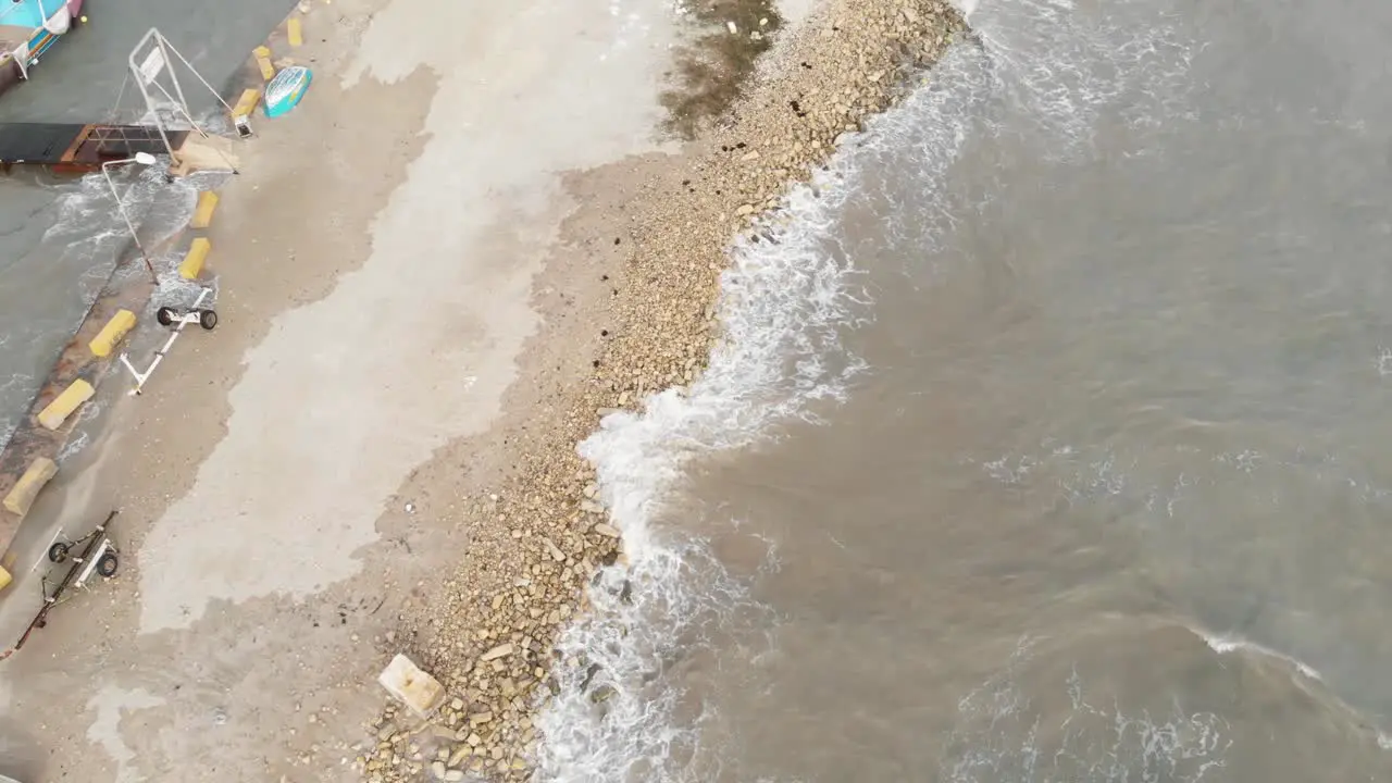 Aerial Top Down Shot Of Small Waves Hitting The Sand In Marsaxlokk Malta