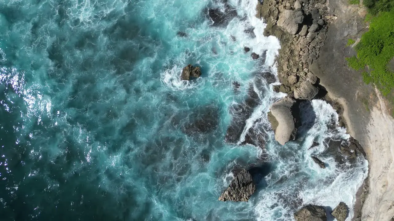 Beautiful bright blue water from a birds eye view with crashing waves in Bali Indonesia