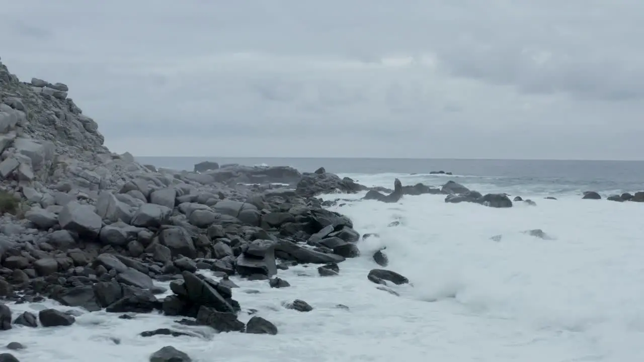 An Unveiling shot of the rocky shore of a beach