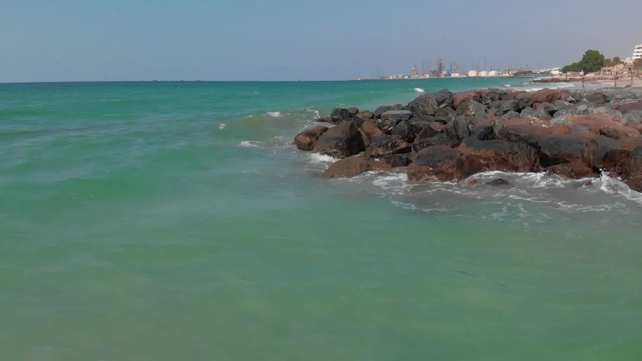 A Cinematic Drone view of the Arabian seashore Bird's eye view of ocean waves crashing against the empty rocks United Arab Emirates 4k footage