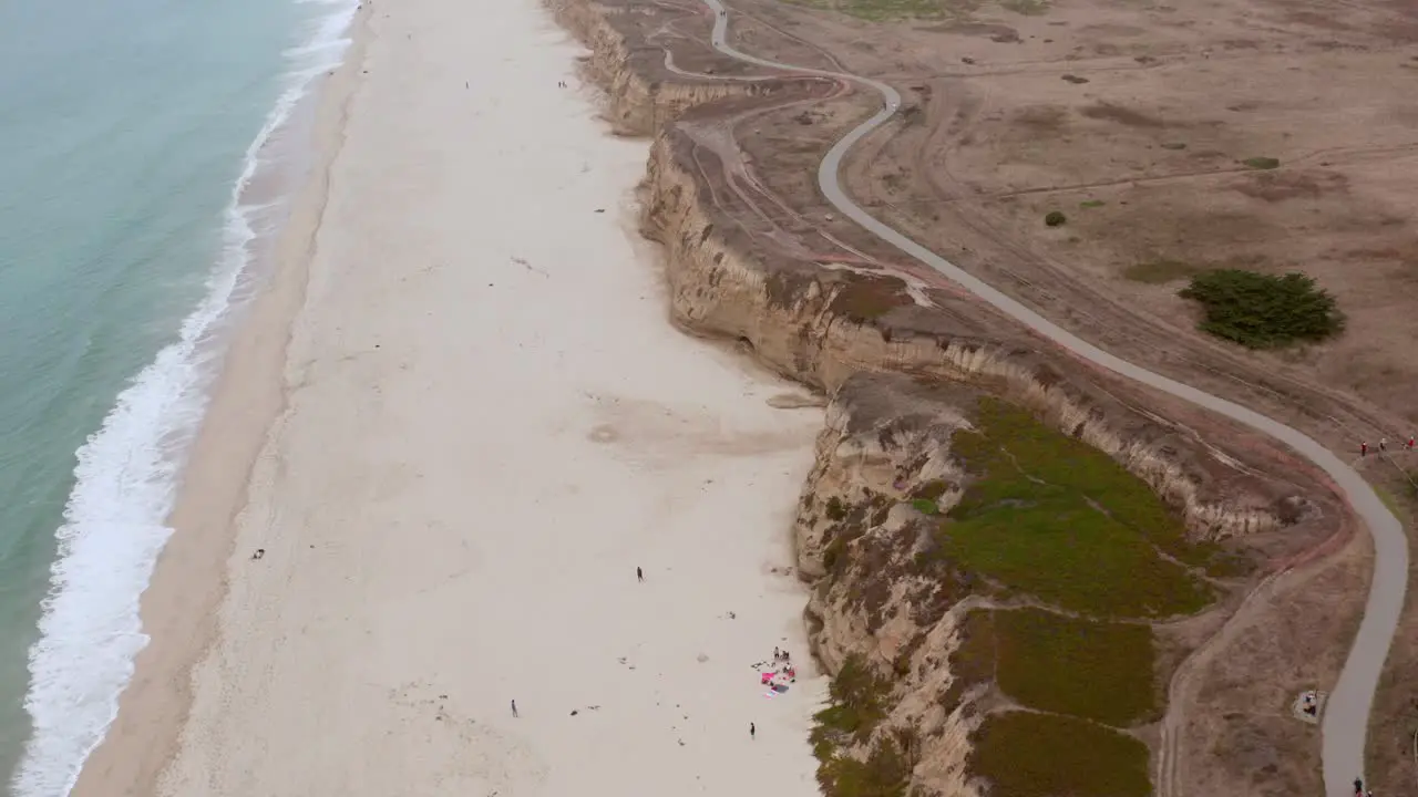 AERIAL drone half moon bay beach cliffs and shore flying forward view