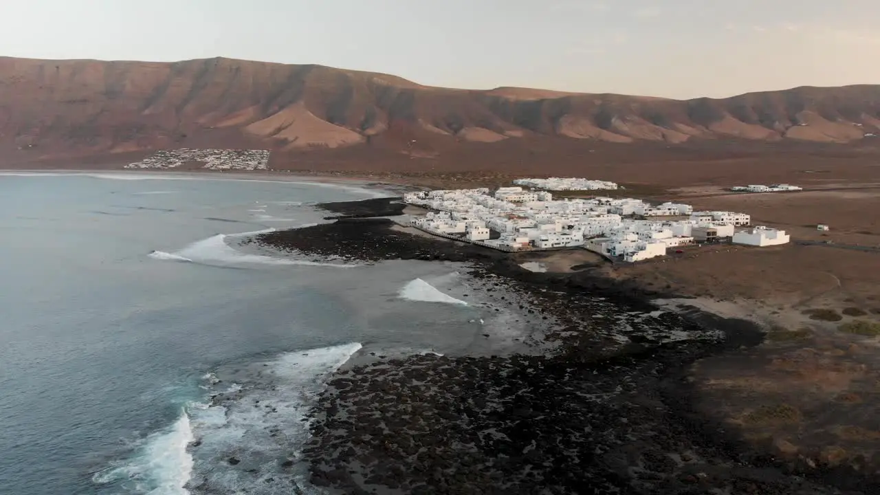 Flying toward a white washed village by a steep mountain side