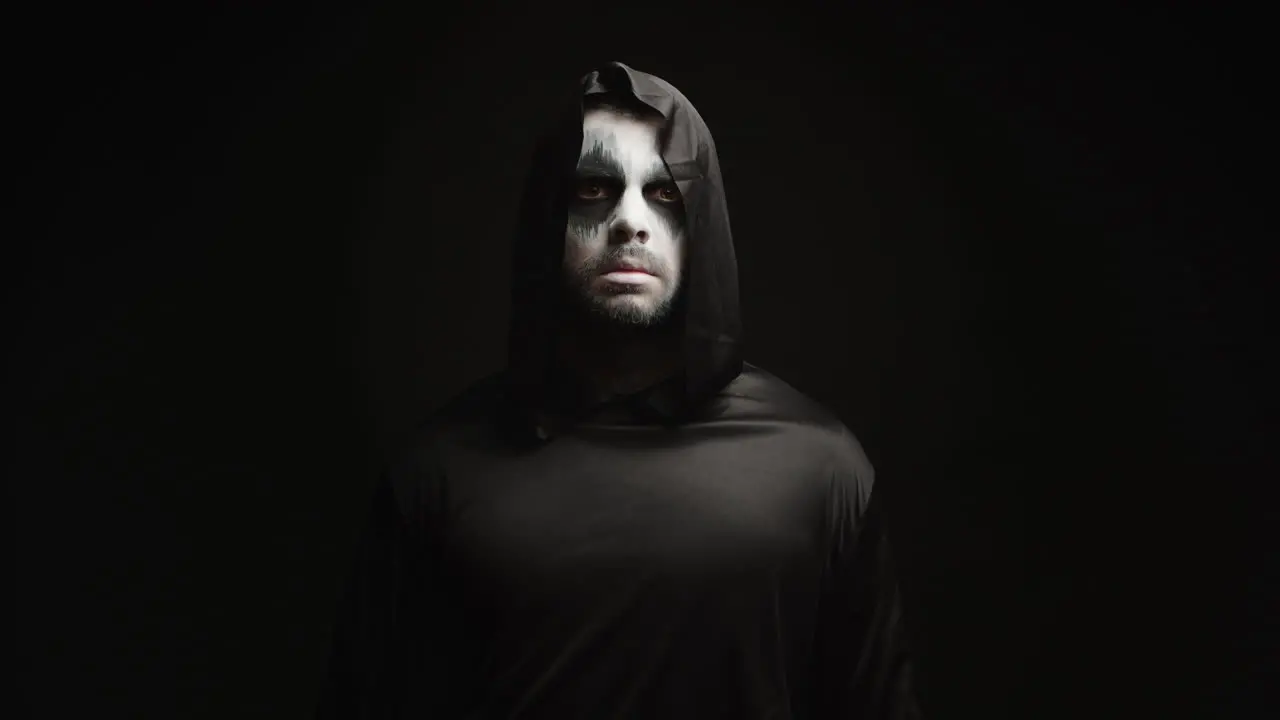 Young man with scary make up dressed up like grim reaper