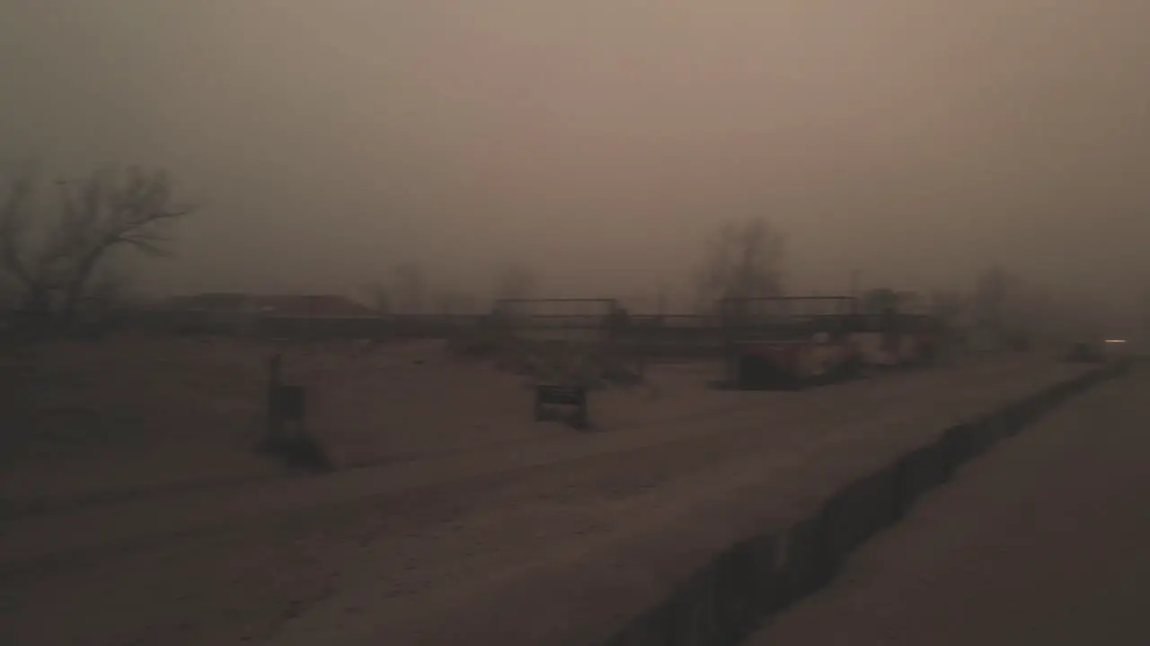 A pan of rolling sand dunes covered in mist off of lake Michigan