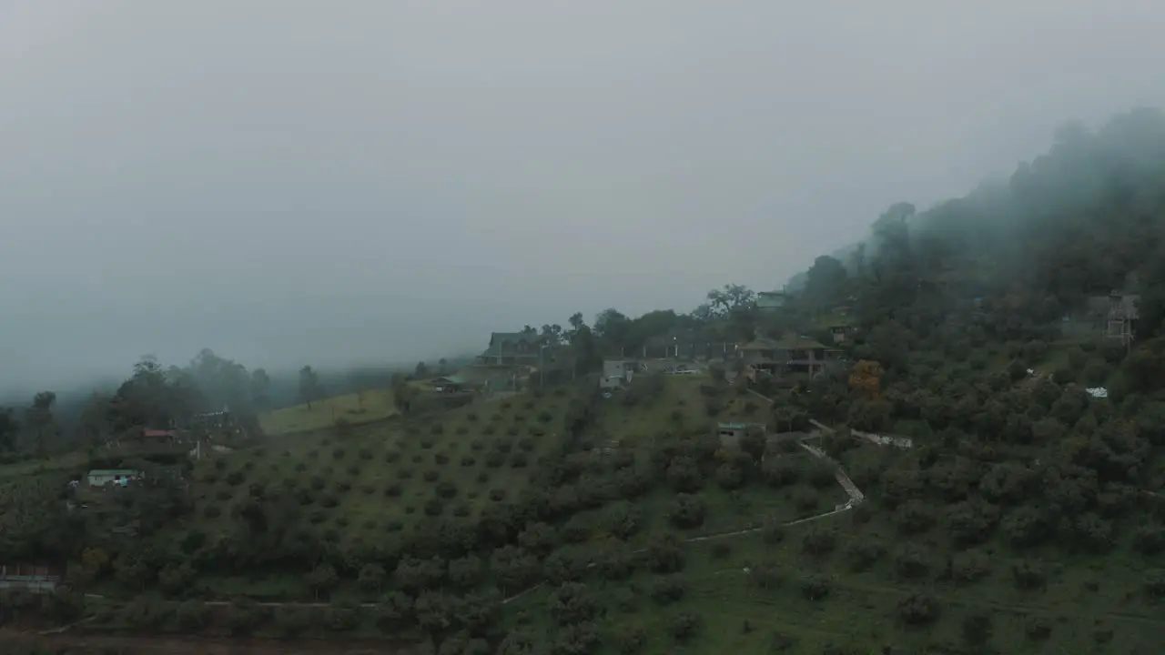 Drone aerial flying over beautiful green hobbit mountains during misty day in Guatemala