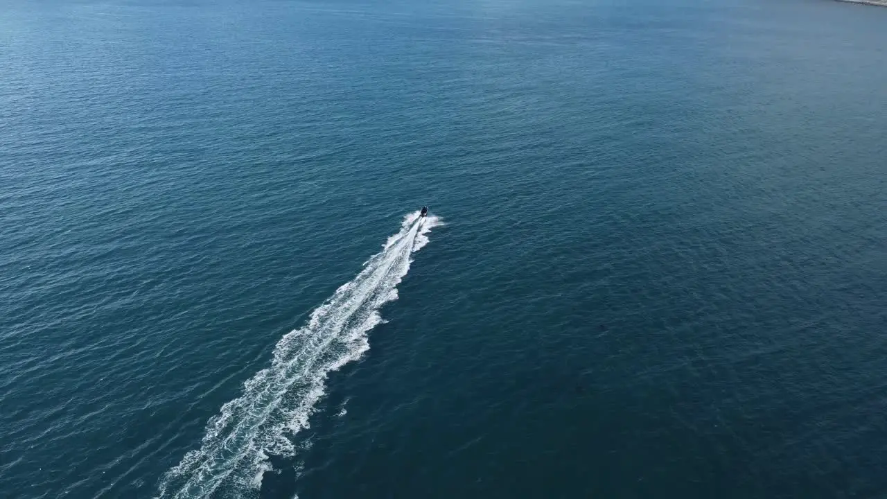 Following a small boat as it speeds through the open ocean