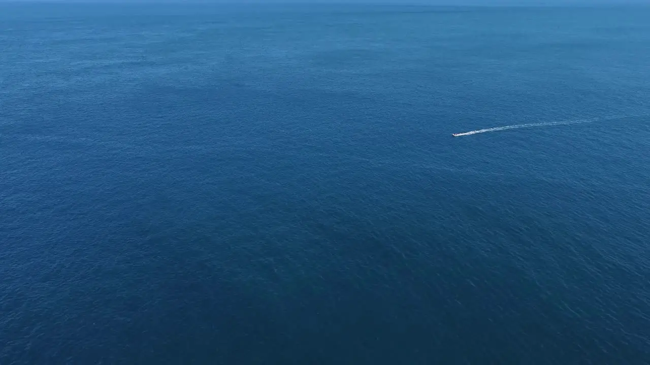 Flying over a boat as it speeds along the open ocean