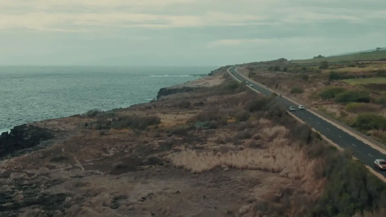 4k Aerial coastal road with traffic near volcanic cliffs