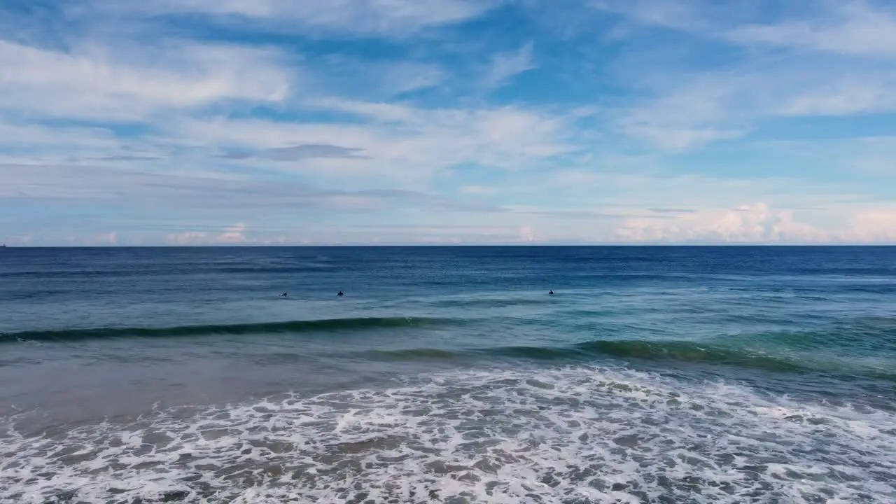 Drone aerial landscape shot view of surfers waiting in Pacific Ocean line-up sandbar bank travel tourism scenery The Entrance Central Coast NSW Australia 4K