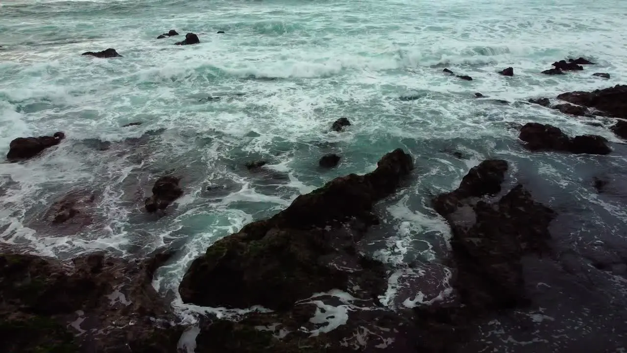 Revealing shot of the ocean in canary island starting with black rocks