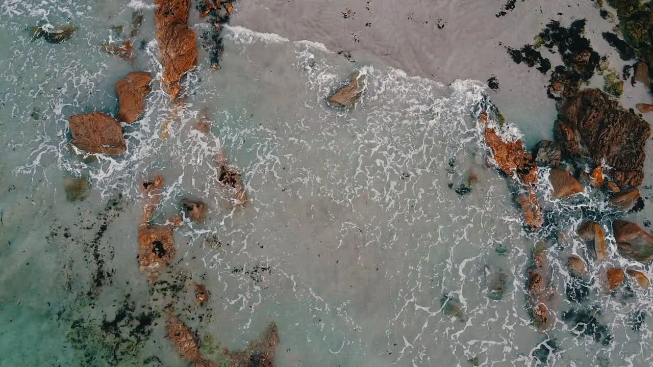 Top view aerial of ocean waves crashing against beautiful natural rocks at West Coast in France