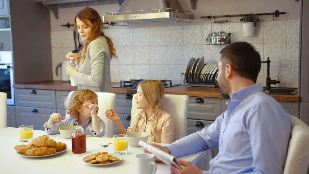 Family Having Breakfast In The Kitchen